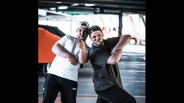 Zwei Männer posieren in einer Parkgarage.